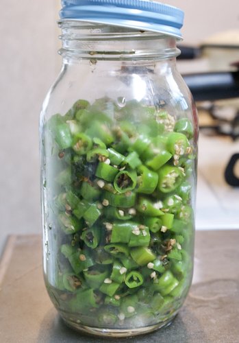 煮沸消毒したビンに青唐辛子を詰める
